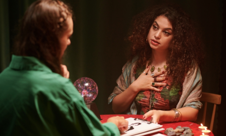 Two women sitting with astrology answers and guidance on the table.