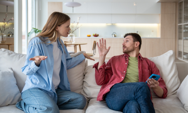 Husband and wife in dispute on the sofa, seeking resolution.
